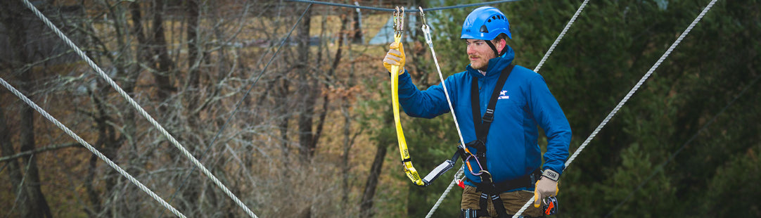 male staff in aerial adventure park wearing ANSI rated PPE